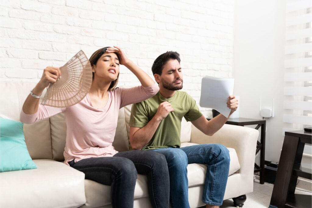 couple fanning themselves while ac is out in home