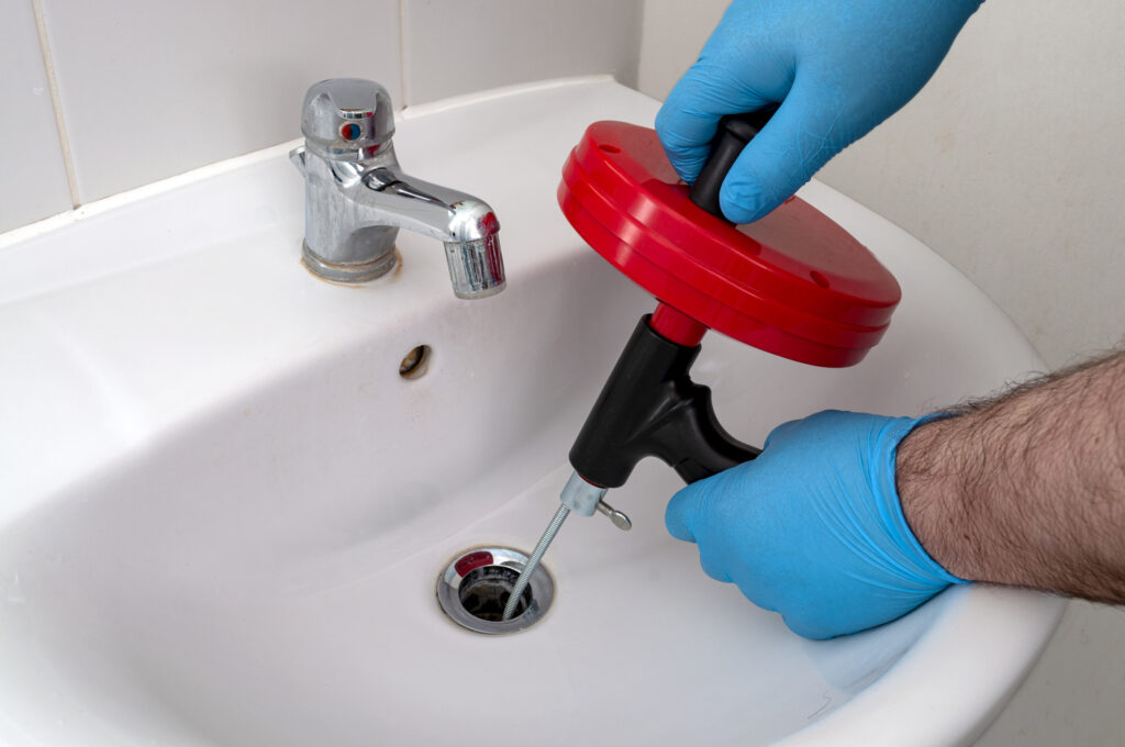plumber unclogging bathroom sink drain