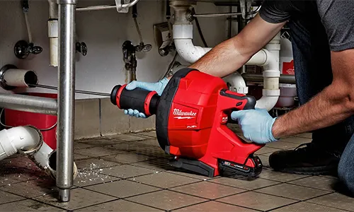 man professionally cleaning kitchen drain